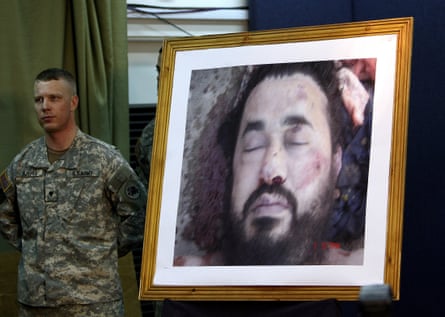 A US soldier stands next to the picture of the dead al-Qaida leader in Iraq, Abu Musab al-Zarqawi, during a news conference at the fortified Green Zone in Baghdad, Iraq on 8 June 2006.