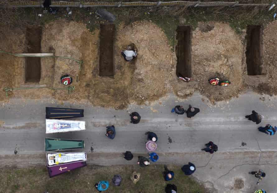 The bodies of four people who died during the Russian occupation await burial during funerals in Bucha, on the outskirts of Kyiv,.