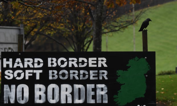 A bird sits near a sign calling for no border in Ireland