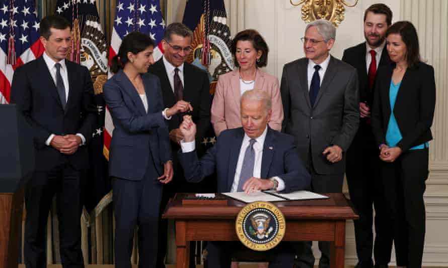 Lina Khan, now chair of the Federal Trade Commission, hands a pen to President Biden as he signs an executive order on ‘promoting competition in the American economy’ in July this year.