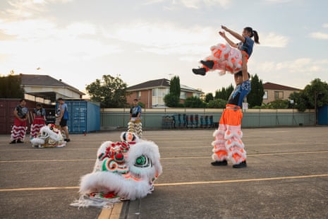 One dancer holds another over his head as the troupe practise in a concrete car park