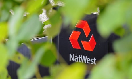 A NatWest bank logo, seen through tree leaves