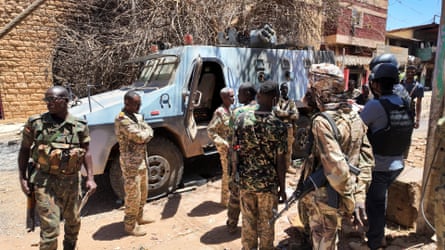 Members of the Sudanese army gather next to a destroyed military vehicles after a battle with Rapid Support Forces (RSF) in Khartoum on 25 March 2025.