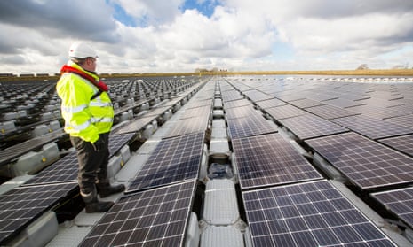 Staff inspect a new floating solar farm at Godley Reservoir in Hyde, Manchester