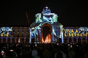 Archive photographs of the Carnation revolution by Portuguese photojournalist Alfredo Cunha projected at Rua Augusta arch in Comercio square in Lisbon on Wednesday night, the eve of the anniversary