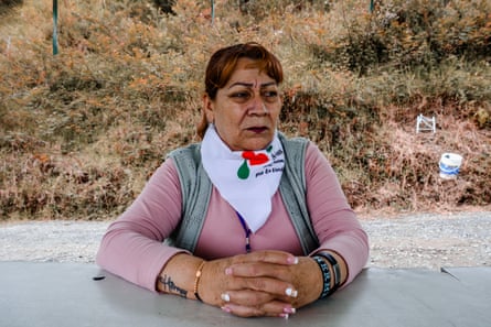 An older woman sits at a table.
