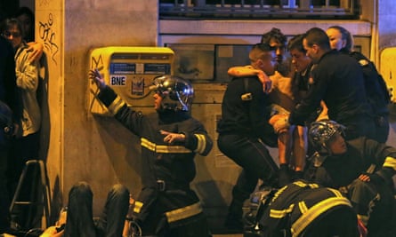 Members of the French fire brigade help an injured individual near the Bataclan concert hall