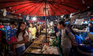 Customers walk around food stalls at Warorot evening market, in Chiang Mai, Thailand.