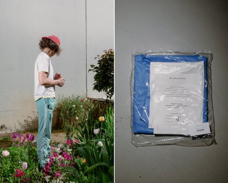 A boy wearing a red cap stands among flowers