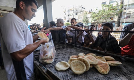 Palestinos fazem fila para comprar pão numa padaria na Cidade de Gaza.