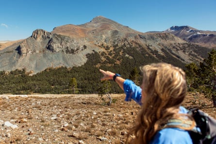 A woman pointing at mountains.