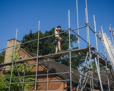 A construction worker standing on scaffolding on a hot morning as the Met Office issue a red extreme heat warning in London and south England.