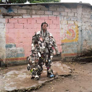 Artist Nada Thsibwabwa posing in his mobile phone costume in Matongé district, Kinshasa. Thirty per cent of coltan, a key mineral for smartphone production, comes from the DRC. Yet every new smartphone has to be imported to Congo at high cost. Kinshasa is a big market for secondhand phones from all ever the world. In Matongé, a whole market is dedicated to repairing old phones.
