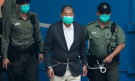 Jimmy Lai is escorted by Correctional Services officers to get on a prison van before appearing in a court at the Lai Chi Kok Reception Center in Hong Kong in 2020.