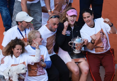 Mirra Andreeva (second right) clutches the trophy as she celebrates with her coach Conchita Martinez (right), her mother Raisa (front, second right) and team members after winning her first grand slam title.
