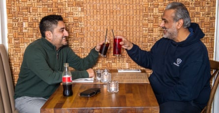 Two men facing each other across a restaurant table