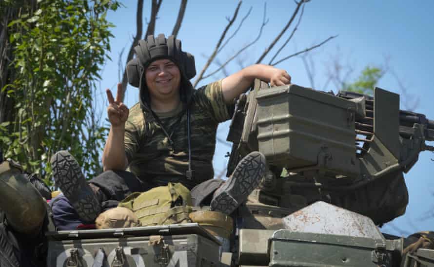 A Ukrainian soldier smiles as he flashes the victory sign atop a tank in Ukraine’s Donetsk region on Monday 20 June.