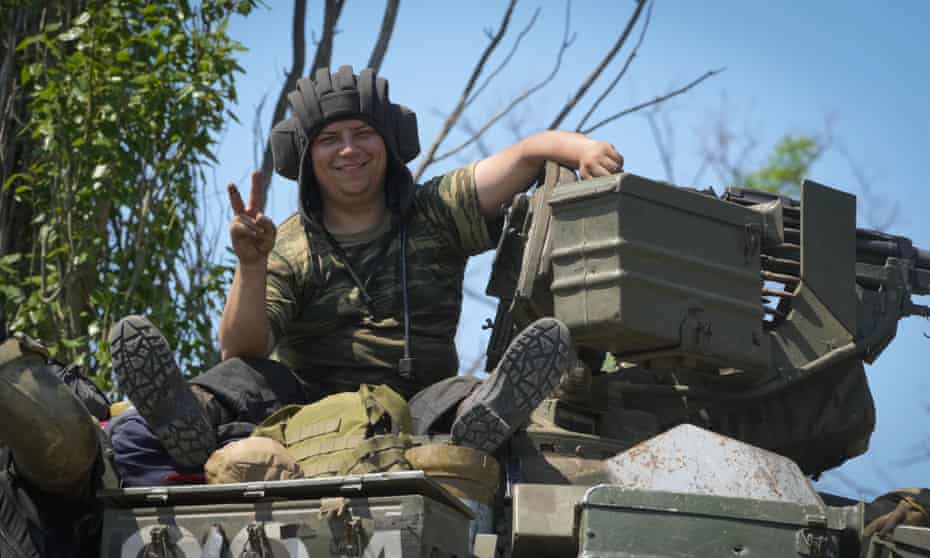 A Ukrainian soldier smiles as he flashes the victory sign atop a tank in Donetsk region, Ukraine on Monday, 20 June 20.