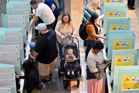 voters at polls, including woman with baby in stroller