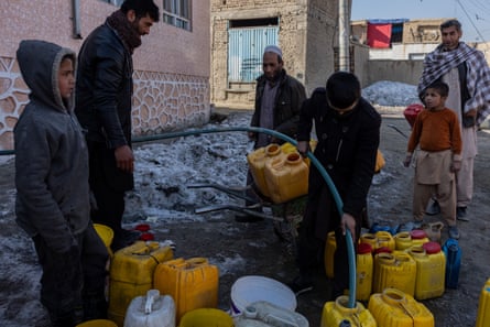 People filling up jerrycans with water for drinking and cooking
