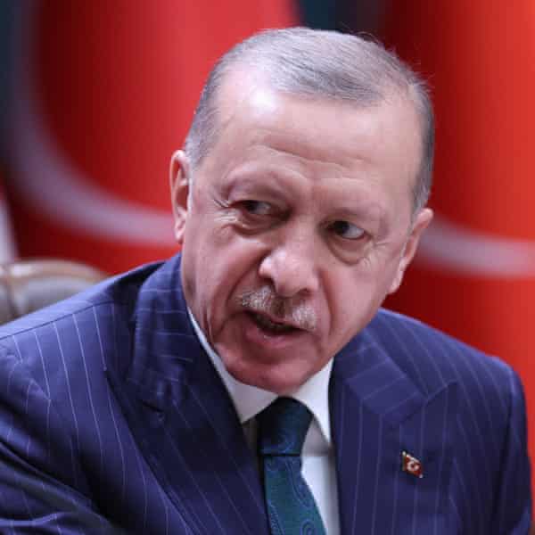 Gros plan du président Erdogan en costume et cravate bleus, regardant quelqu'un hors caméra