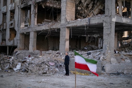 A man stands in front of the ruins of buildings in a residential area in Tehran, Iran.