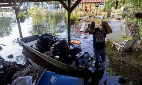 Daniel Stover, 17, wipes his head as he helps rescue people’s belongings in Sorrento, Louisiana, on Saturday.