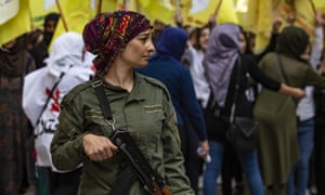 A member of the Kurdish internal security services known as Asayish stands guard during a demonstration by Syrian Kurds against the Turkish assault on north-eastern Syria in Qamishli on 28 October.