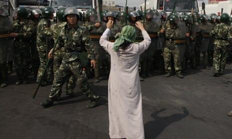 A Uighur woman protests before a group of Chinese paramilitary police in China’s Xinjiang region in 2009. 
