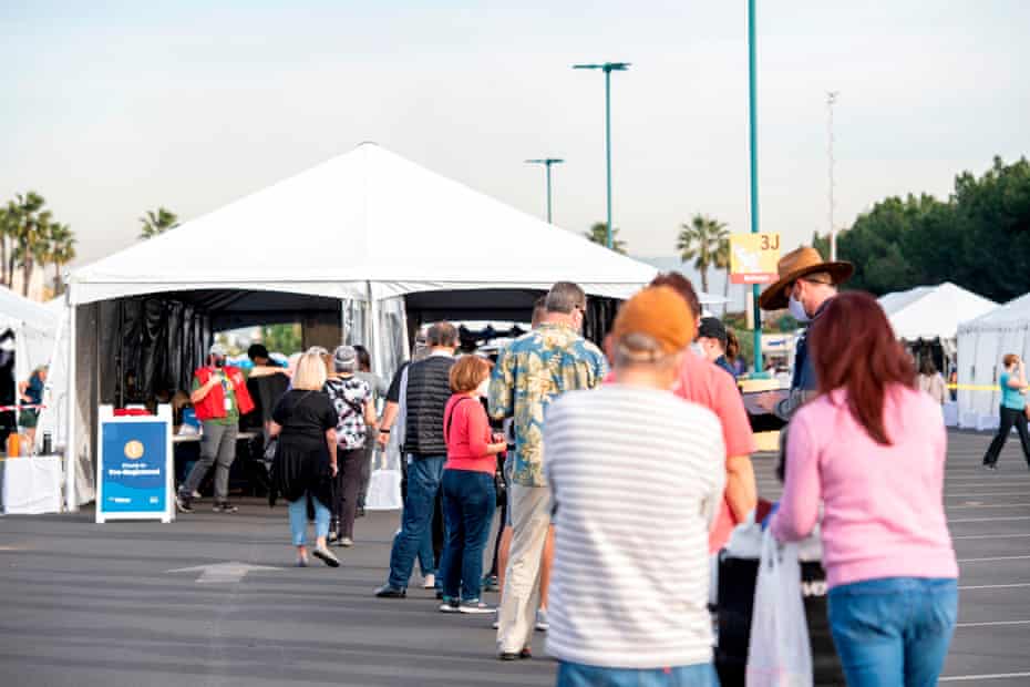 People wait in line in a Disneyland parking lot in California to receive Covid-19 vaccines.
