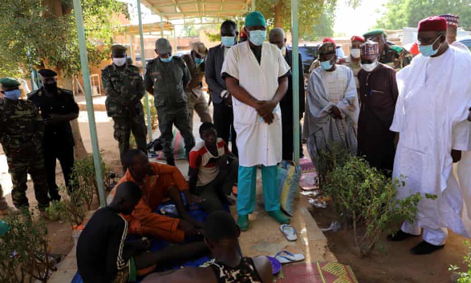Civilians wounded in an earlier attack in Niger in January 2021 meet Niger’s interior minister, Alkache Alhada, at a hospital in Ouallam.