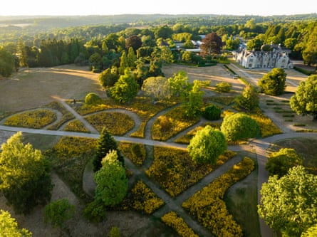 An aerial picture of gardens surrounded by trees and a large white Elizabethan mansion