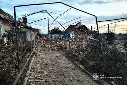 wreckage of cottages and a path through gardens or allotments with rubble to either side.