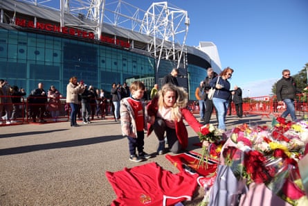 Tributes are laid in memory of Sir Bobby Charlton by the United Trinity statue at Old Trafford