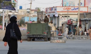 A woman passes a Taliban checkpoint outside Hamid Karzai International Airport in Kabul