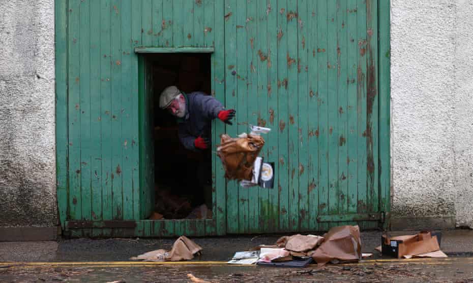 A man clears out his lockup after it was flooded when the river Tweed burst its banks in Peebles, Tweeddale. 