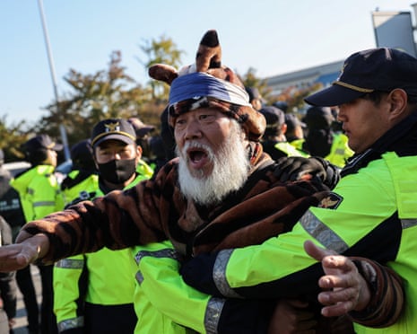 Police stop an anti-China protester near Gimhae airport