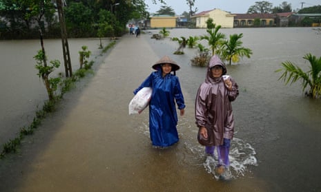 Women wade through flood waters in Quang Tri province on 16 October. 
