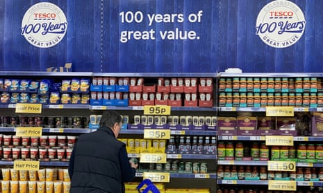 Man by tins of produce at a Tesco store.