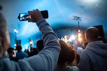 An audience member recording a band at a festival – millions of unauthorised videos end up on YouTube.