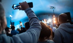 Audience member recording a band on their mobile phone