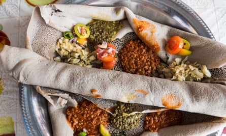 A traditional Injera dish with variety of vegetables and sauces.