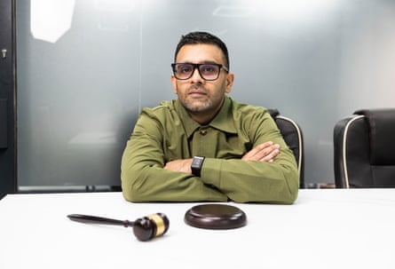 Akhmed Yakoob sitting at a desk with a gavel in front of him