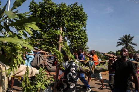 Africans use long poles to carry bodies wrapped in cloth