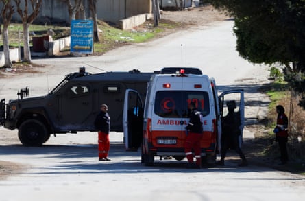 A tank next to an ambulance with soldiers checking inside ambulance.