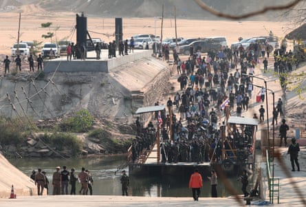 People stream down a concrete walkway onto a pontoon.
