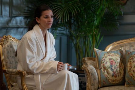 A young woman sitting in big white bathroom in a beautifully decorated and luxurious room