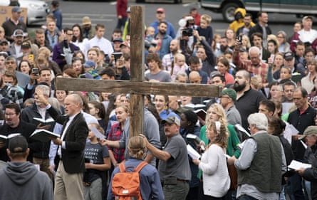 People in crowd carry cross