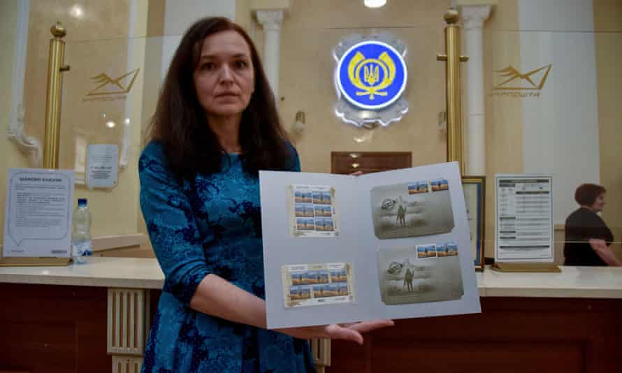 A woman in a post office in Lviv shows off the postage stamp presentation packs.