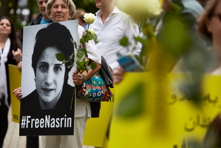 People march holding #FreeNasrin placards and flowers